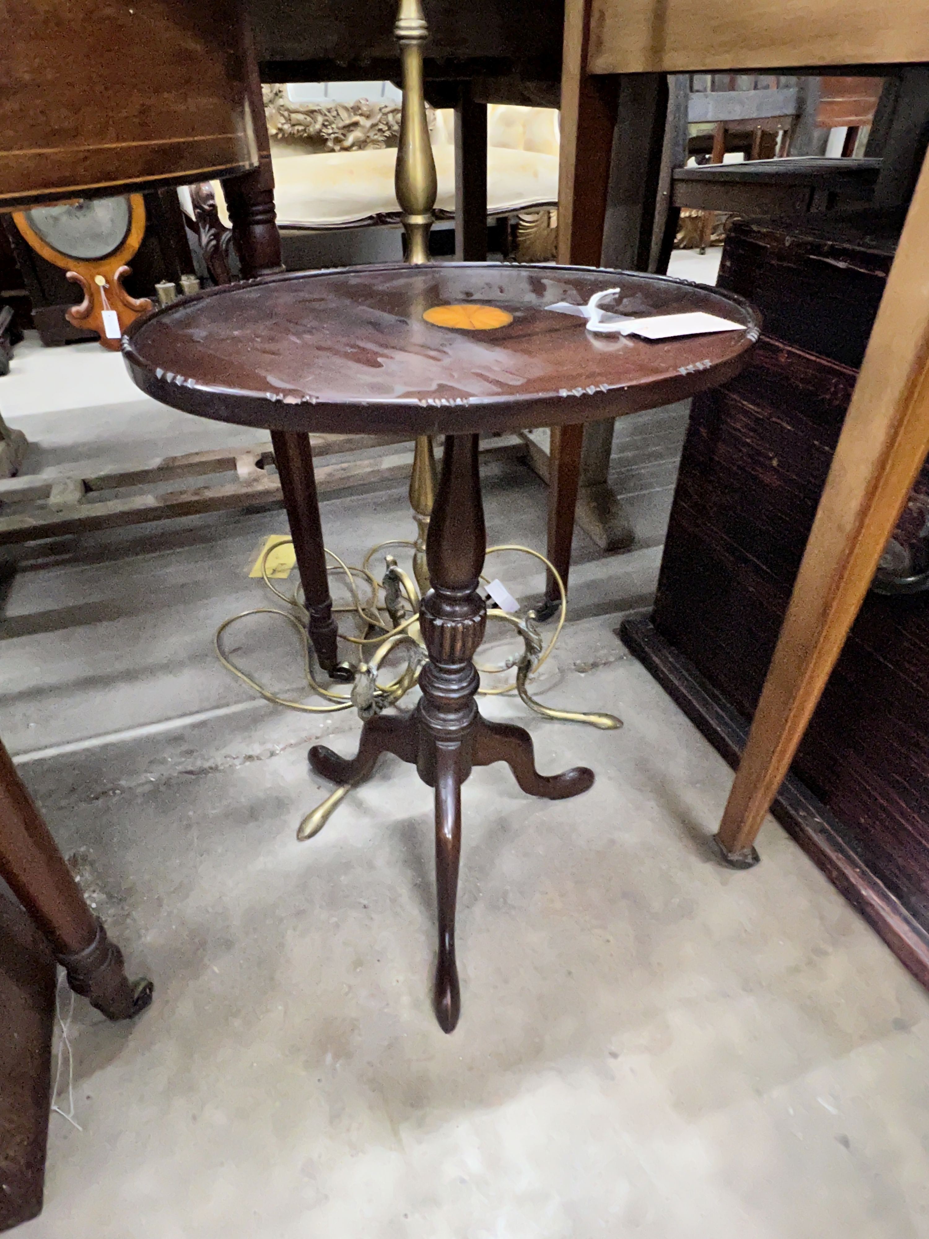 A brass standard lamp on scrolled supports and an oval top mahogany tripod wine table